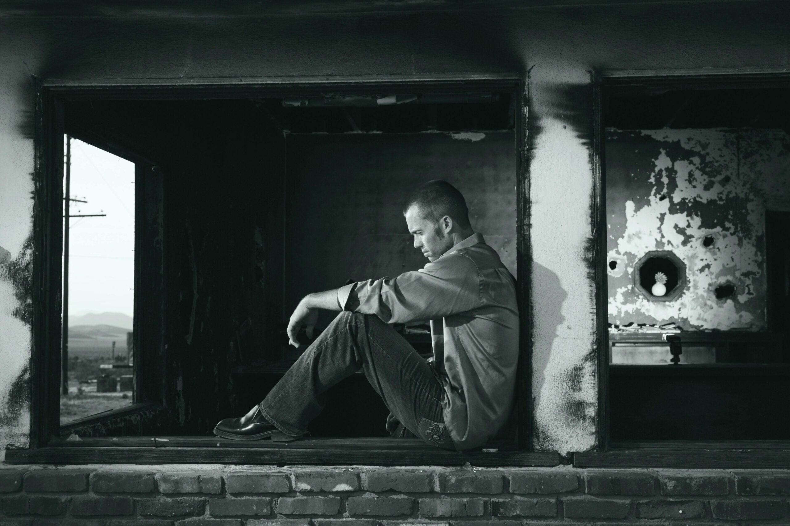 Grayscale Photo of Man Sitting