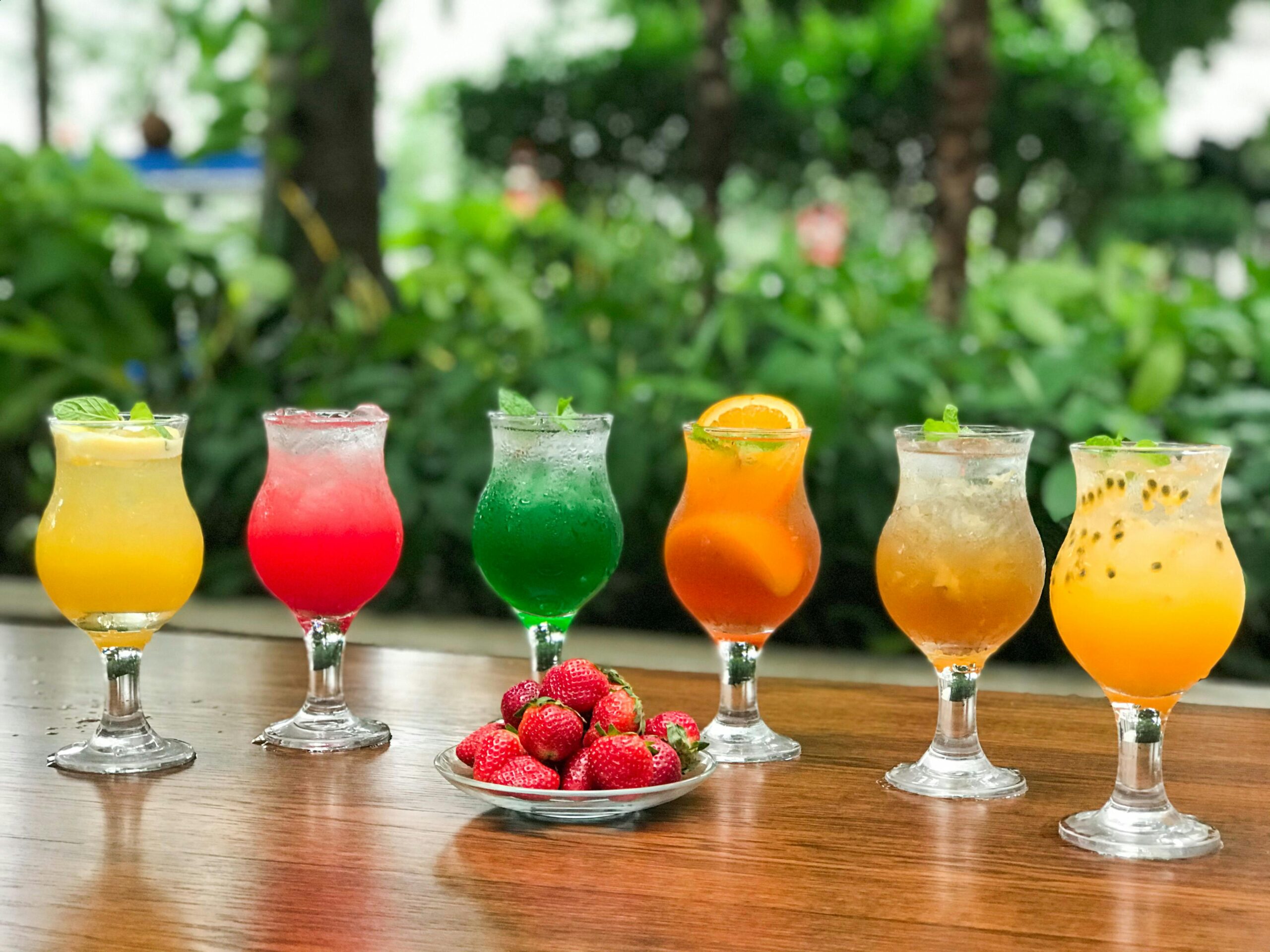 A Bunch of Colorful Cocktails and a Plate with Strawberries