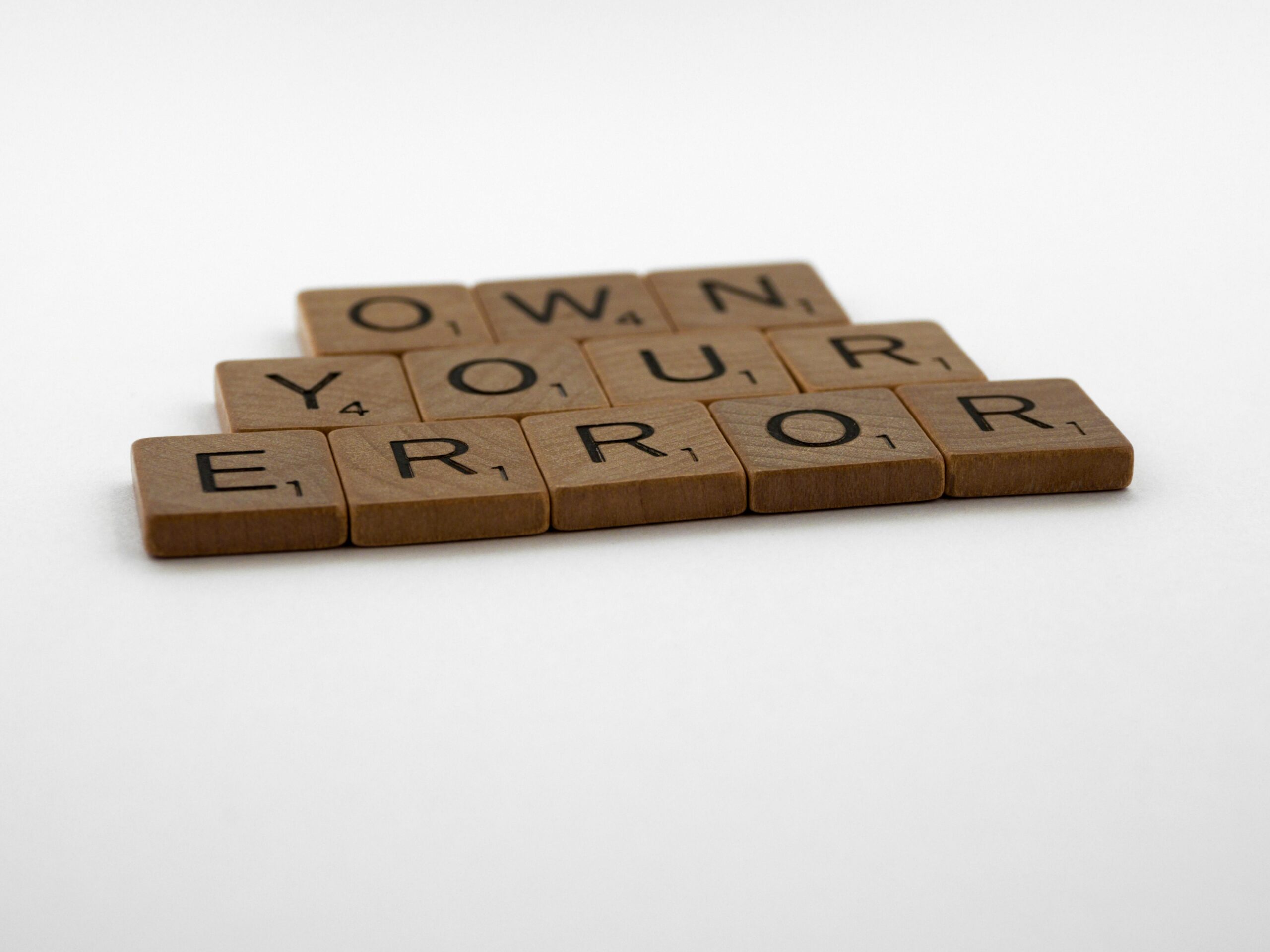 A motivational phrase assembled with Scrabble tiles on a white background.