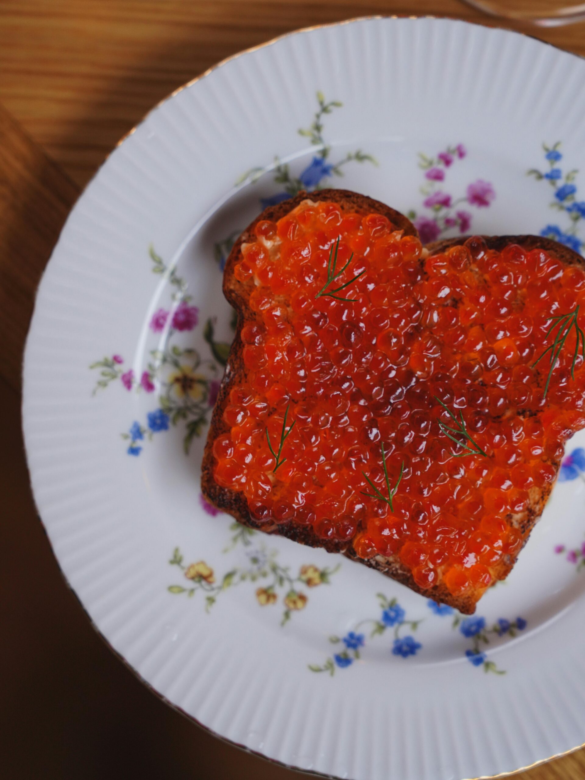 Close-up of vibrant caviar on toast on a decorative plate, perfect for breakfast settings.