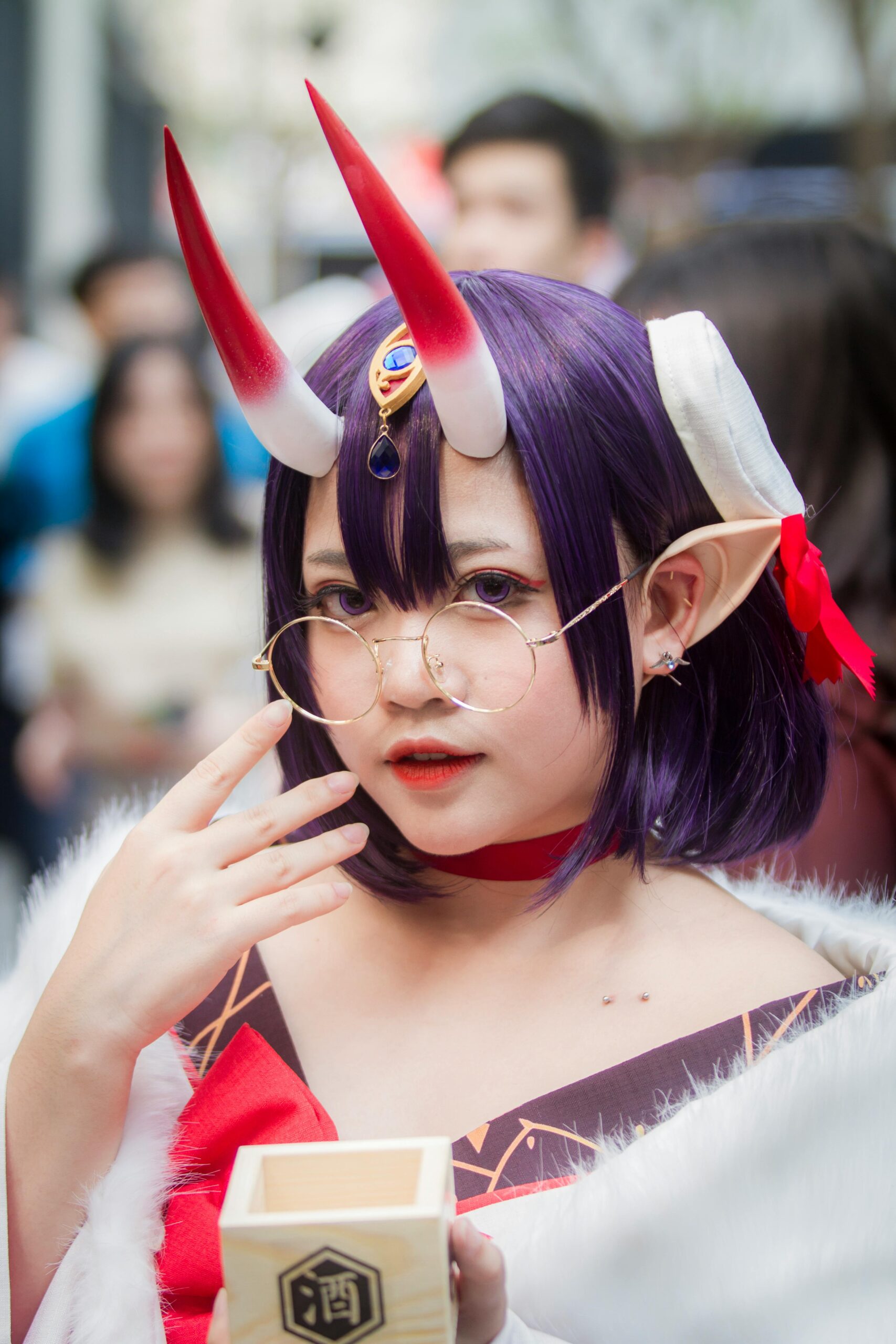 A striking cosplay portrait of a woman with purple hair and red horns, captured outdoors.
