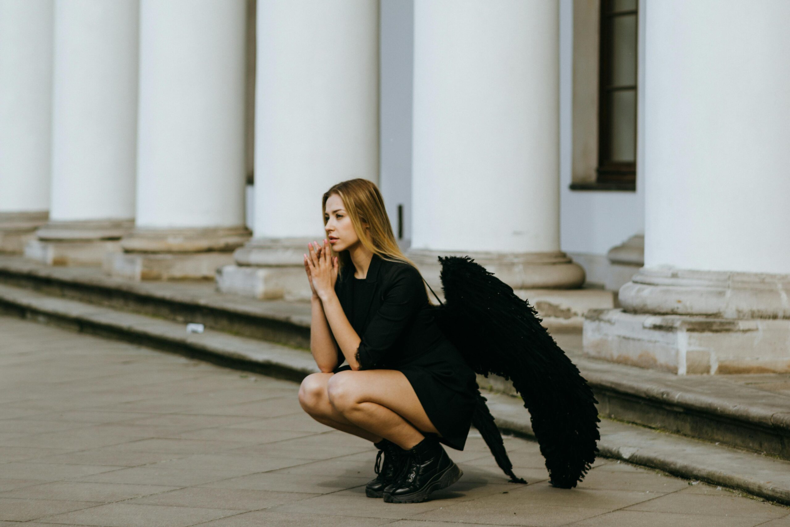 A woman in a black outfit with wings, evoking an ethereal ambiance.